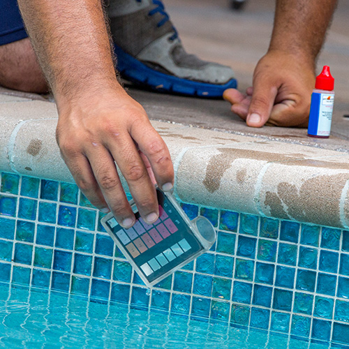 Person testing the PH of a pool